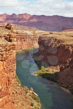 The majestic landscape. Green water of the Colorado River in the steep banks of red sandstone desert