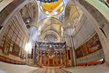 Church of the Holy Sepulcher in Jerusalem. Huge beautifully decorated hall in front of the Edicule. Hall is beautifully lit sunlight through windows in the domed ceiling and lamps. The picture was tak