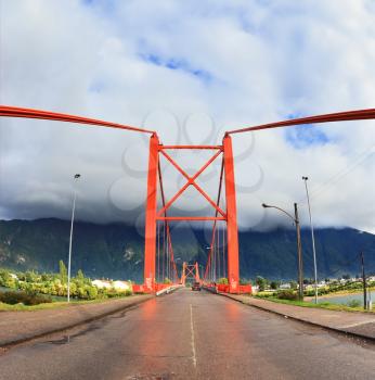 Patagonia, Chile. Red bridge over the fjord. A gorgeous summer day and a huge cloud. The picture was taken Fisheye lens