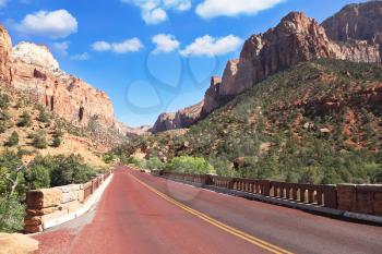 Zion National Park, USA. Excellent with red asphalt road among the picturesque mountains of orange and red sandstone