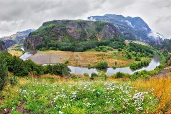 The river picturesquely bends around the hill, forming horseshoe.  Chilean Patagonia, the road Carretera Austral