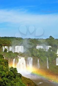 The most famous waterfalls in the world - Iguazu. Magnificent rainbow is above the thundering water jets.