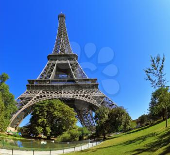 The picture was taken Fisheye lens. Huge and beautiful Eiffel Tower. At the foot of the tower is designed park with paths and pond