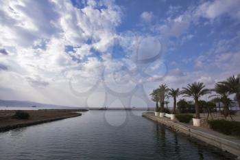 The channel with transparent greenish water, and palm trees on coast