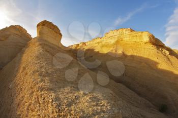 Hills of soft picturesque forms from sandstone on a sunset