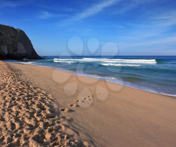 Portuguese Atlantic coast. Long and wide sandy beach in Sintra. Early morning sun