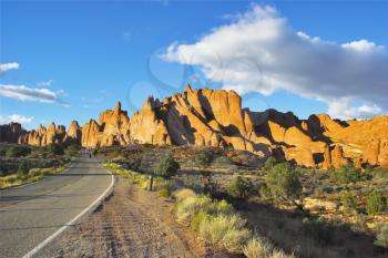  Road among freakish natural stone formations in the well-known park Arches in the USA