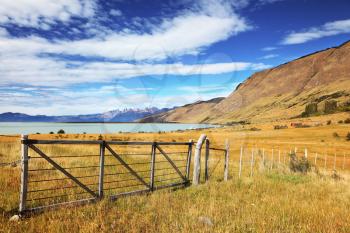 Lake in the high valley of the Patagonian Andes. The fence placed to protect grazing cows