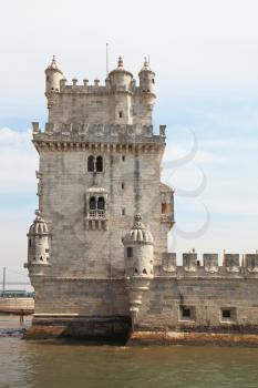 The famous Tower of Belem in the water of the river Tagus. White marble tower is decorated with turrets and battlements in the Moorish style