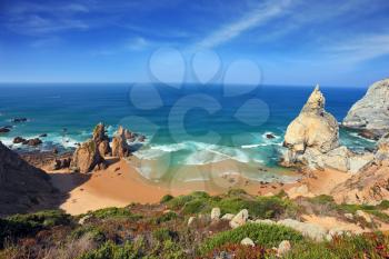 Portuguese Atlantic coast. Bizarre sandstone rock on the small beach in Sintra. Several tourists were roasting in the sun