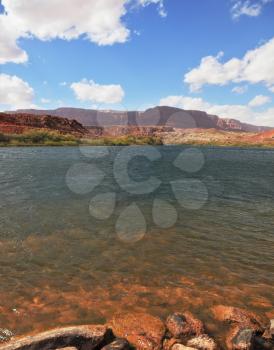 Cold and clear water of the Colorado River between the steep banks of red sandstone