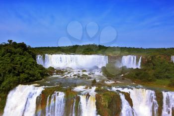 The roaring waterfalls in South America - Iguazu. Blanker jet fall between green jungle. Magnificent rainbow shines in the mist