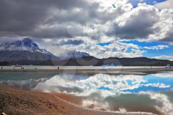 The mysterious glow. Bright reflections of sky and clouds in the smooth cold water of Lake Grey. Chilean Patagonia, National Park Torres del Paine