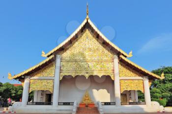 The brightly decorated entrance to a Buddhist temple in northern Thailand.
 In the gallery - the golden figure of a seated Buddha