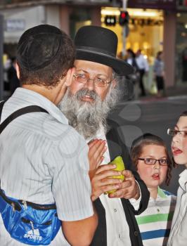 BENE - BERAK, ISRAEL - SEPTEMBER 17, 2013:  The elderly man with gray-haired beard chooses a citrus.  Big market on the eve of Sukkot