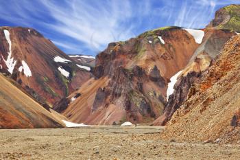  Colorful smooth mountains in the Icelandic reserve Landmannalaugar. In the hollows is last year's snow. Rhyolite mountains