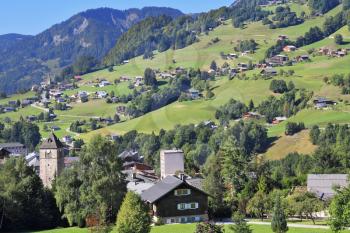 The charming landscape in the French Alps. Sunny Sunday afternoon in the Haute-Savoie. Green alpine meadows and lovely houses - chalets