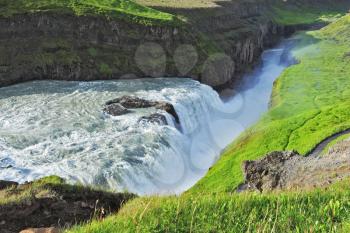 Grand Gullfoss. Iceland. In mid-July, bubbling water illuminated by a bright morning sun