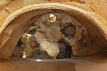 Bell caves of Beit Guvrin. Israel National Park.  Picturesque clay arches illuminated by the sun from the hole at the top and side entrances
