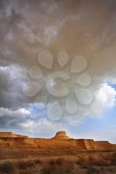Huge cloud of the freakish form above stone desert. Spring in Israel