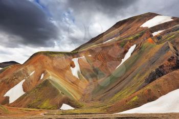 Multicolored rhyolite mountains with the remnants of last year's snow in July. The famous Valley Landmannalaugar in Iceland