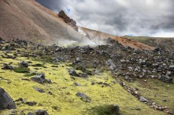 Iceland in July. Rhyolitic mountains smoke underground heat. In hollows last year's snow lie