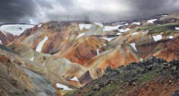 The famous Valley Landmannalaugar. Multicolored rhyolite mountains with the remnants of last year's snow. July in Iceland.