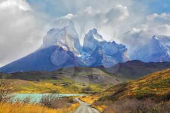 Summer day in the national park Torres del Paine, Patagonia, Chile. A dirt road leads to the cliffs of Los Kuernos