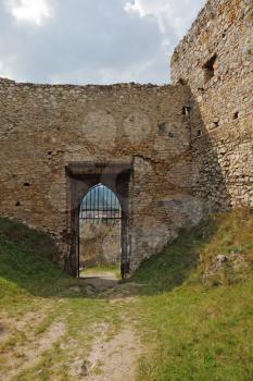 Barred gates and walls of the ruined medieval citadel in Slovakia.