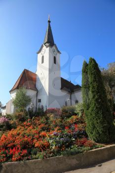 Church clearly look elegant against the clear blue sky. Church built on a hill and surrounded by flowers