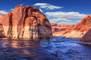 Walk around the lake Powell at sunset. Scenic huge artificial pond Powell on the Colorado River, USA. The lake is surrounded by picturesque banks of orange sandstone
