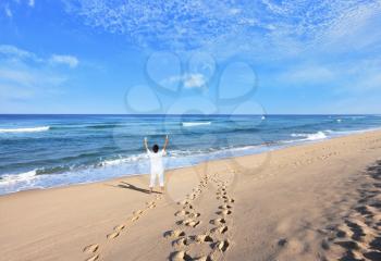  Middle-aged woman dressed in white doing yoga. Huge beautiful beach on the Atlantic coast. The seaside resort of Sintra