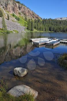 Small boats made of white metal on a quiet mountain lake