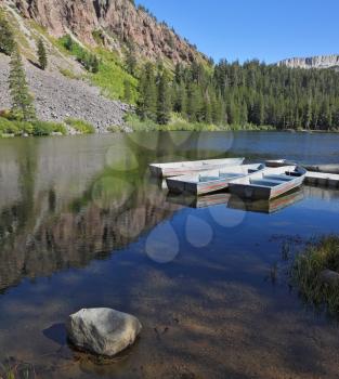 Small boats made of white metal on a quiet mountain lake