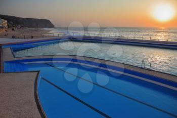 A huge beautiful pool on the beach. Atlantic coast, the Portuguese resort of Sintra, a prestigious hotel, sunset