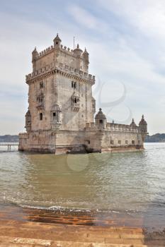  Portugal, Lisbon.  The famous Tower of Belem in the water of the river Tagus. White marble tower is decorated with turrets and battlements in the Moorish style.