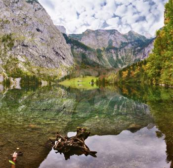 Cloudy day on the lake. Magic reflection in German lake Koenigssee. Clouds and mountains reflected in the mirrored surface of the water