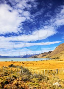  The fence placed to protect grazing cows. Lake in the high valley of the Patagonian Andes