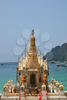 A small pagoda, beautifully decorated, an ocean coast.  Thailand 