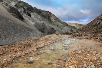 Creek in the gorge between the mountains of black volcanic ash.  National Park Landmannalaugar in Iceland