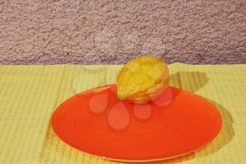  Ritual fruit - citron on orange plate and yellow napkin. Jewish holiday of Sukkot