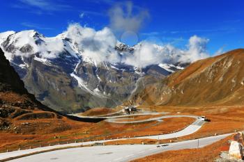Famous picturesque views of the road in Austrian Alps - Grossglocknershtrasse. Ideal highway winds high in the mountains. The highest mountain peaks covered with fresh snow
