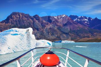 Ice and sun Patagonia. Excursion on the tourist boat on Lake Viedma.  White-blue huge icebergs float near a ship board