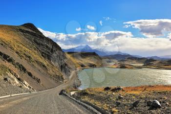 Patagonia, Chile. Gravel road along the shore of the lake with the cold blue water. 