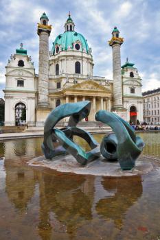 VIENNA, AUSTRIA - SEPTEMBER 26, 2013: Saint Karl Borromey's well-known church in Baroque style. On the square in front of church a big pond with a sculpture the Modernist style