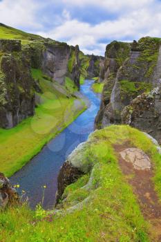  The picturesque canyon  Fjadrargljufur, green grass of rocks and blue ribbon of the river. Dreamland Iceland
