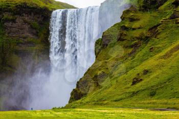 Magnificent famous waterfall Skógafoss, Iceland. A powerful jet Skógar river falls from a large glacier