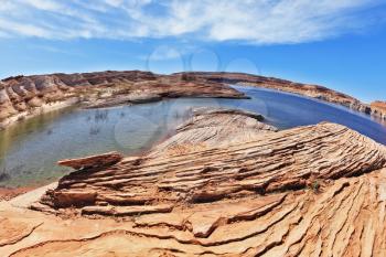 Magnificent Lake Powell. The small bay in the middle of the desert rock of red-orange striped sandstone. Photo taken fisheye lens