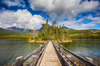 Jasper National Park, Pyramid Lake. Cold sunny morning. The picturesque little island in the middle of the lake and the wooden bridge