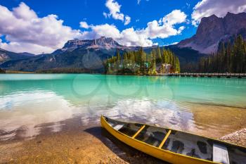 In shallow water the small boat is moored. The concept of eco-tourism and active tourism. The mountain Emerald lake Yoho National Park